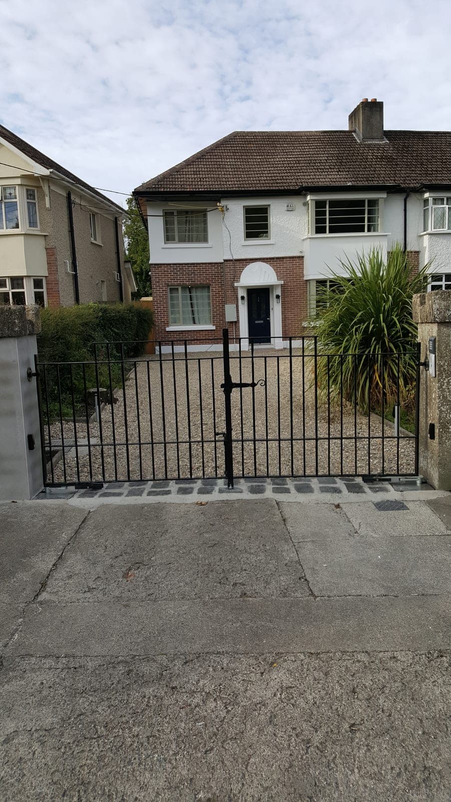 Front of the house with a gated gravel driveway