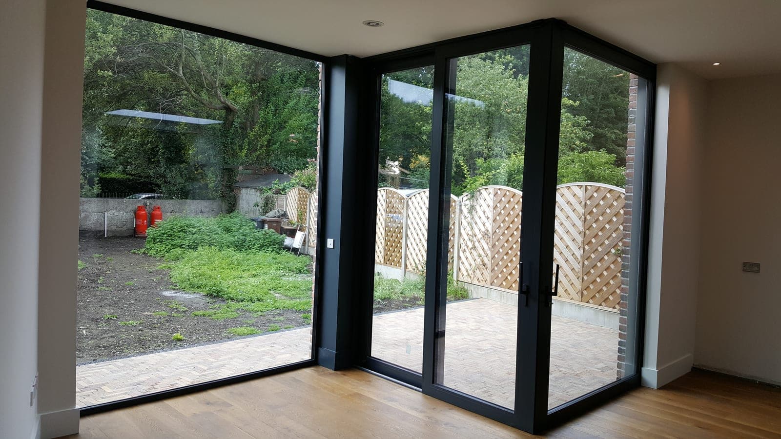 Floor-to-ceiling corner glazing looking out to the garden