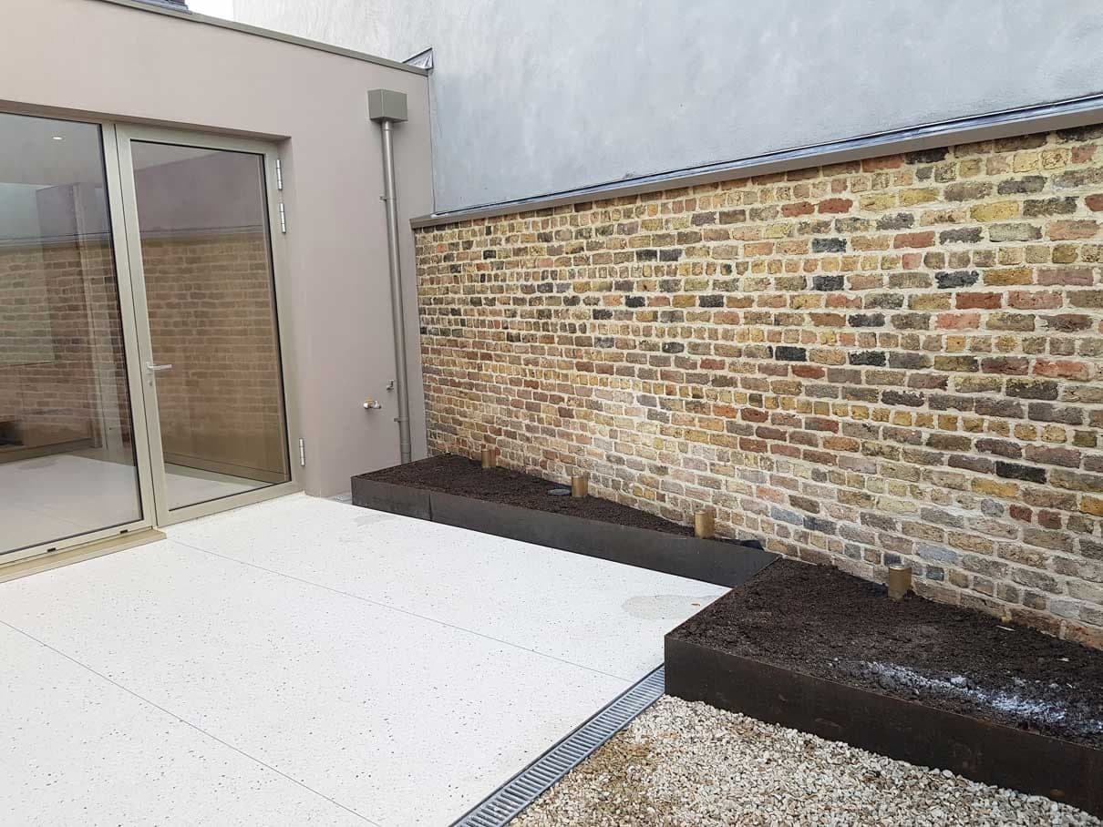 Courtyard with sliding glass doors and a restored brick boundary wall
