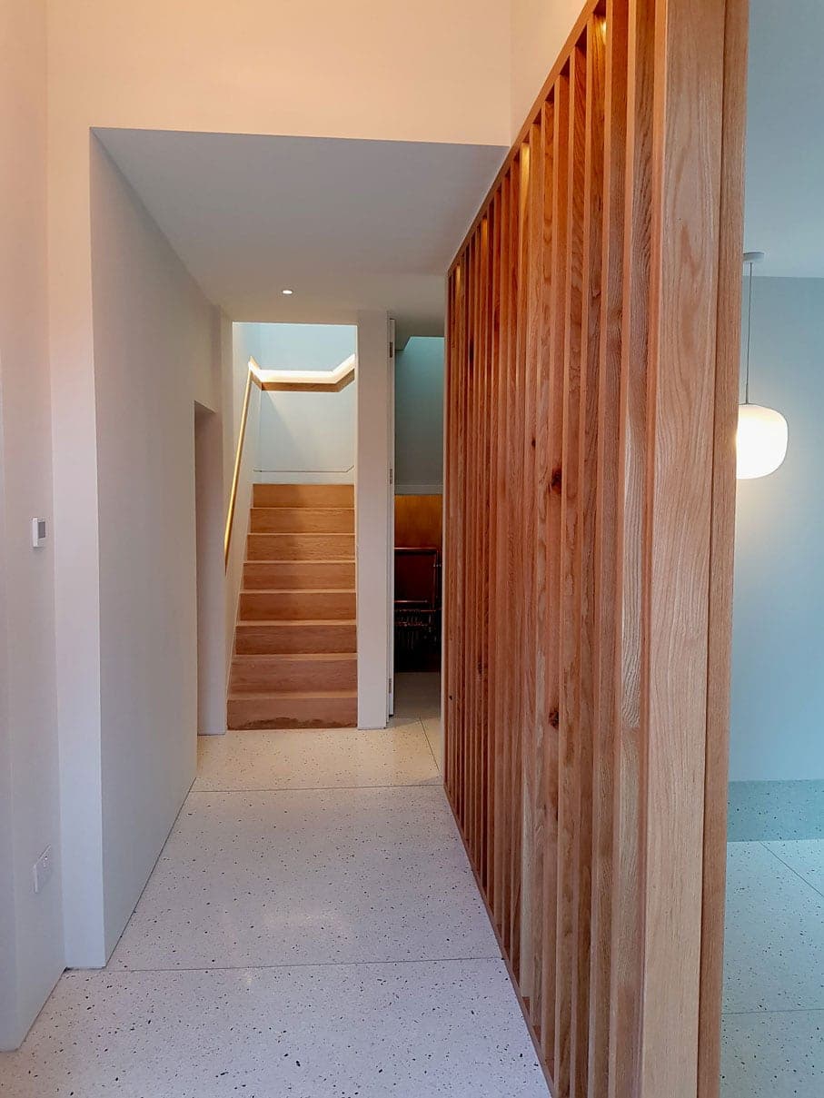 Hallway with a slatted timber screen leading to the stairs