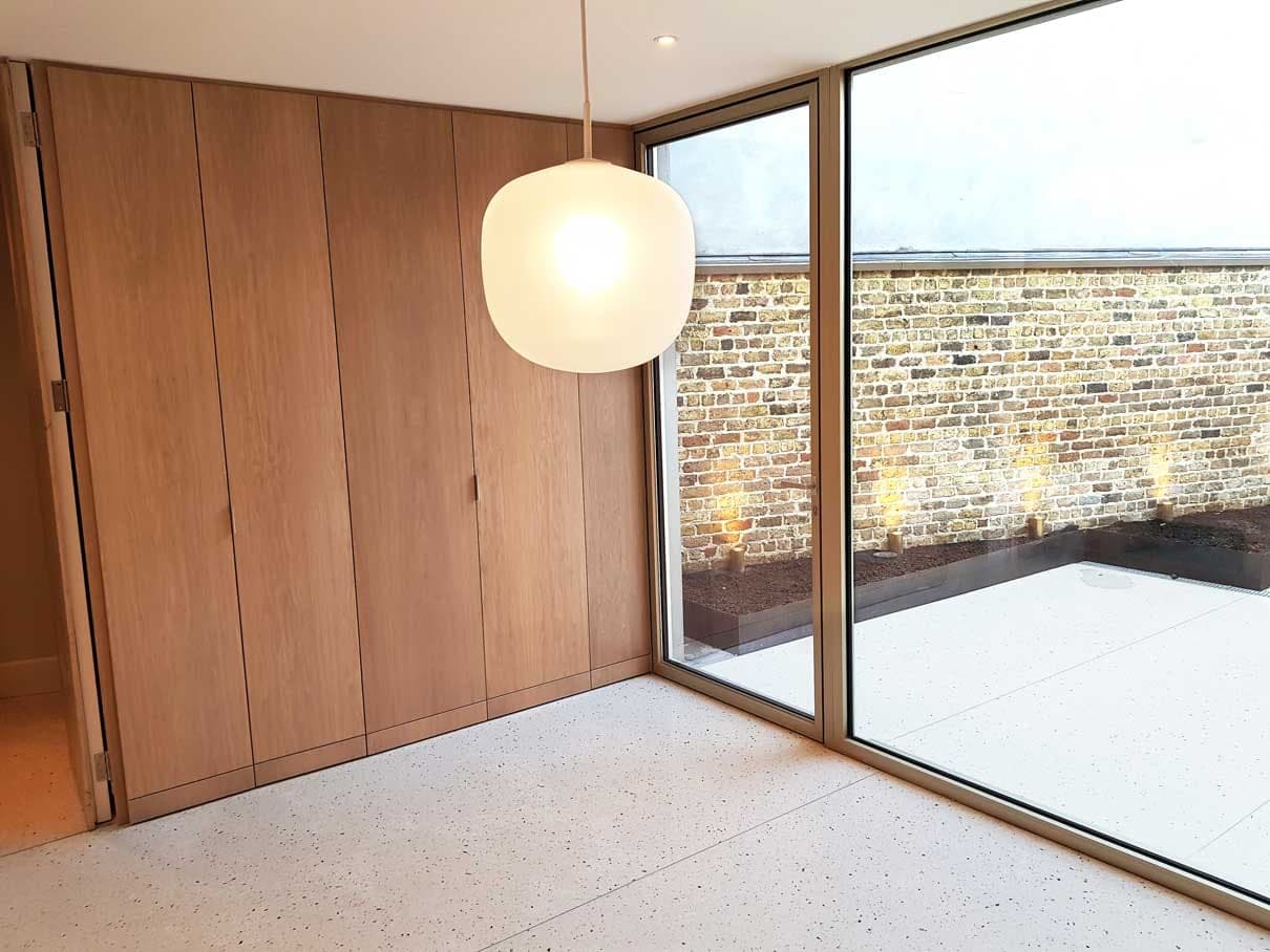Full-height oak joinery beside floor-to-ceiling glazing