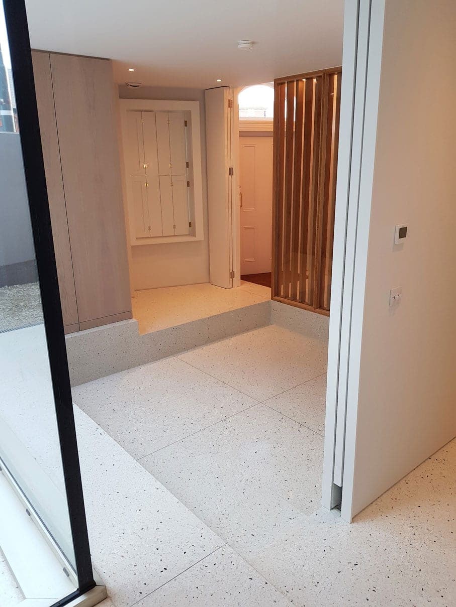 Terrazzo hallway with timber slats and hidden storage