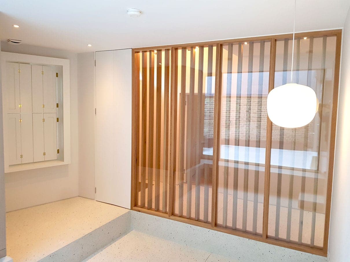 Slatted timber screen and pendant light over a terrazzo floor