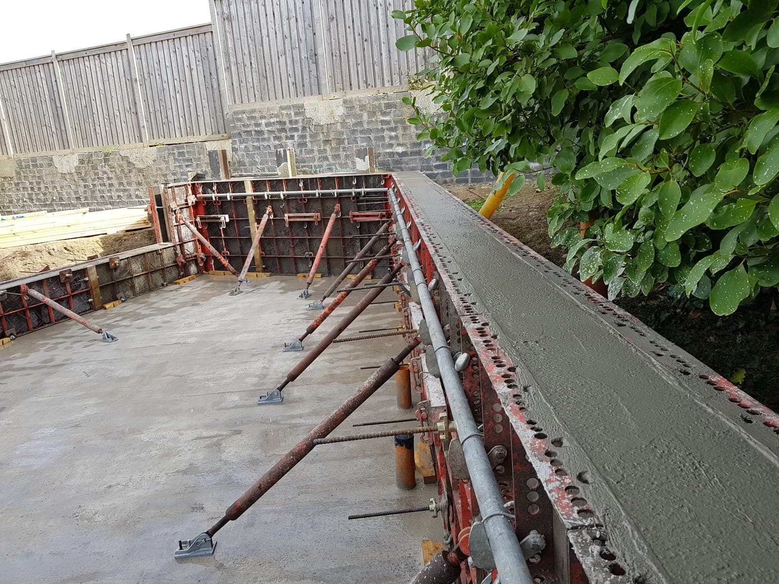 Concrete poured into steel formwork, supported by props